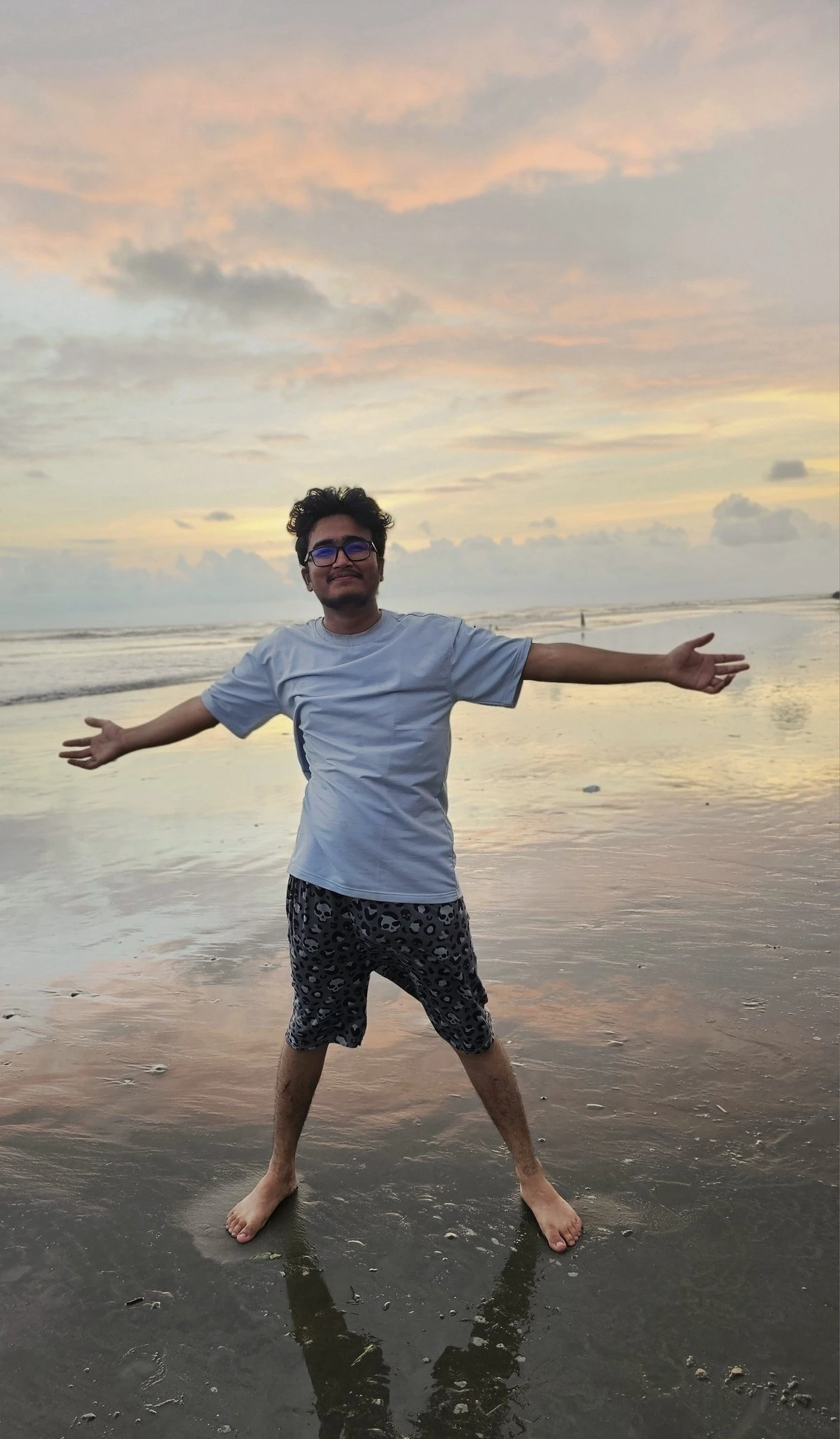 Arms wide open on the beach at sunset